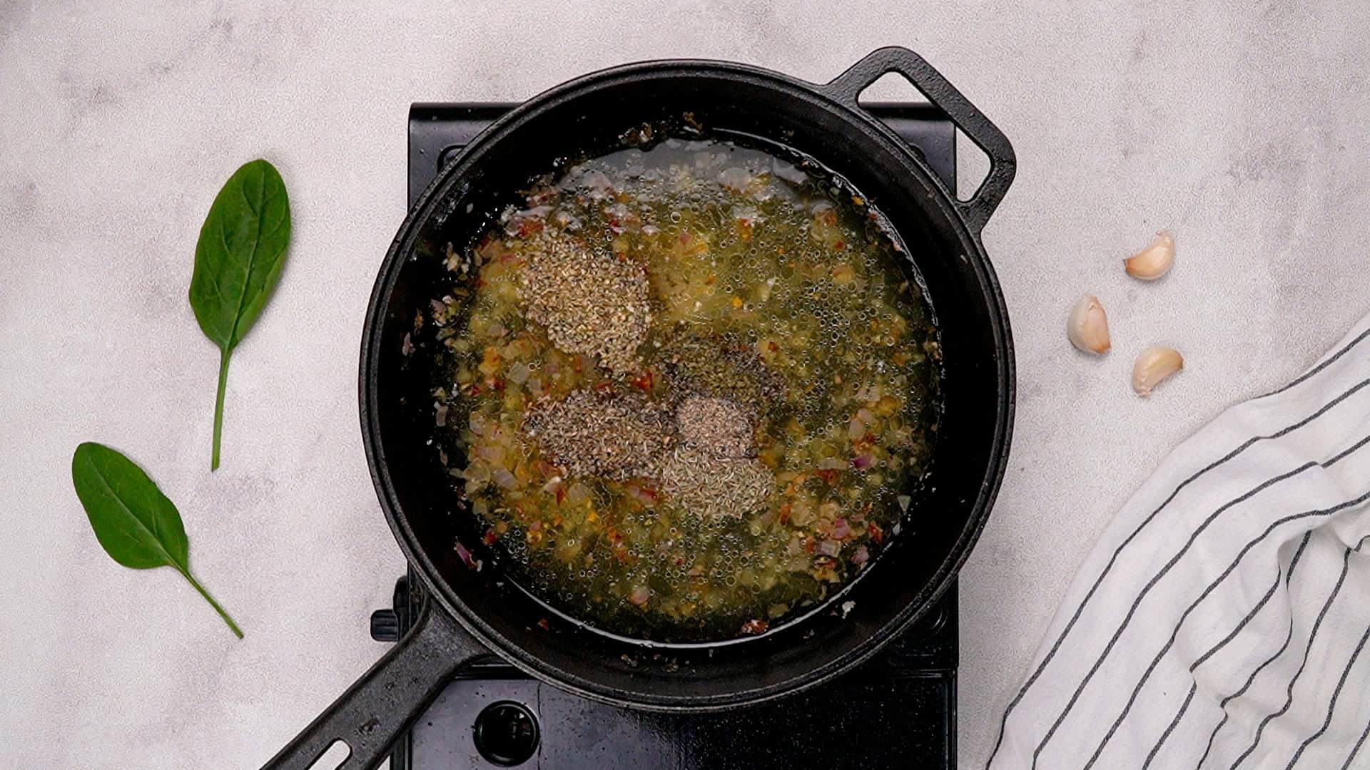 Lower the heat to medium. In the same skillet, melt the butter, then sauté the minced shallot and garlic for about 20 seconds until fragrant. Pour in the chicken broth and add the dried herbs, salt, and pepper. Let it simmer for about 3 minutes, or until it reduces a bit.