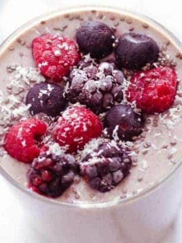 close up of berry green smoothie in small glass