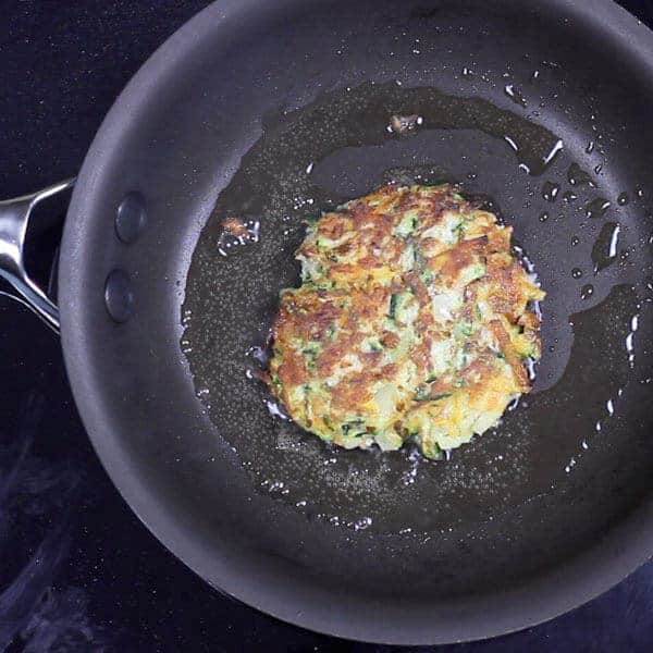 cooking a fritter in a black skillet pan