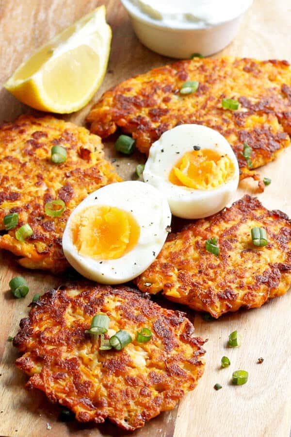 sweet potato rosti laid on a wooden cutting board with hard boiled eggs