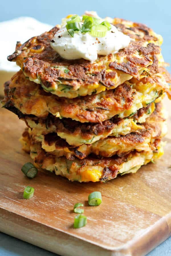 zucchini haloumi fritters on a wooden chopping board