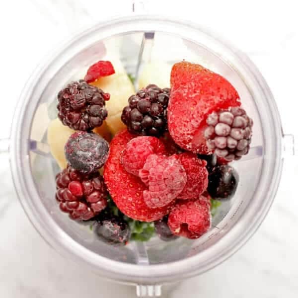 berry smoothie ingredients in a blender cup