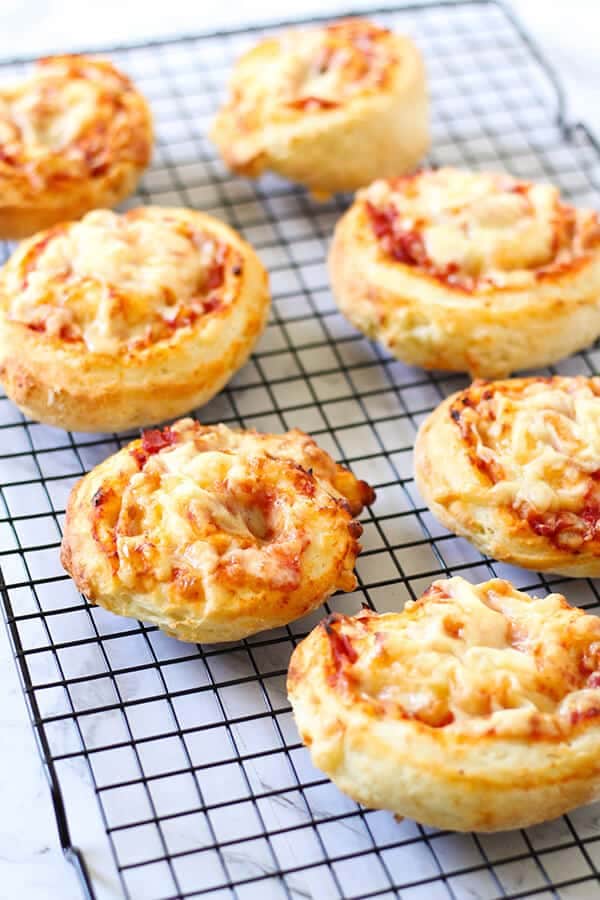 ham and cheese scrolls on a wire cooling rack.