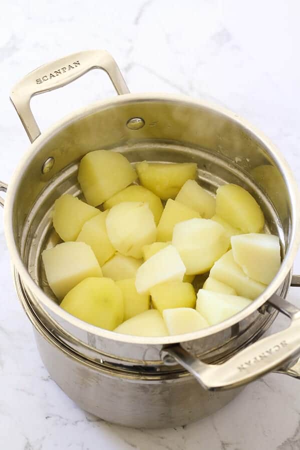 Potato pieces in a silver colander.