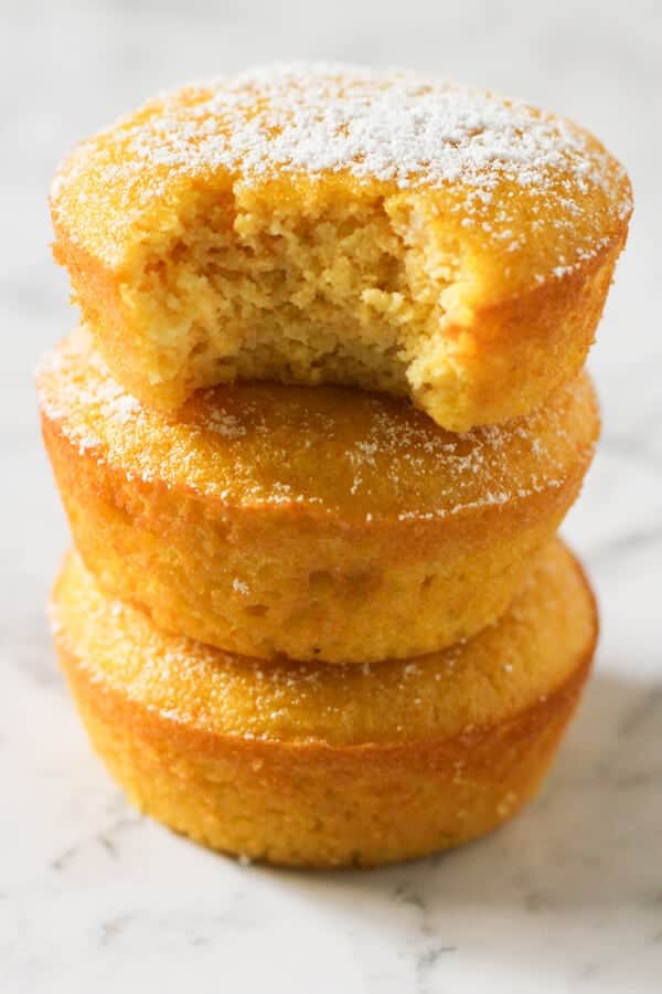 Orange and almond cakes stacked on top of each other on a marble board.