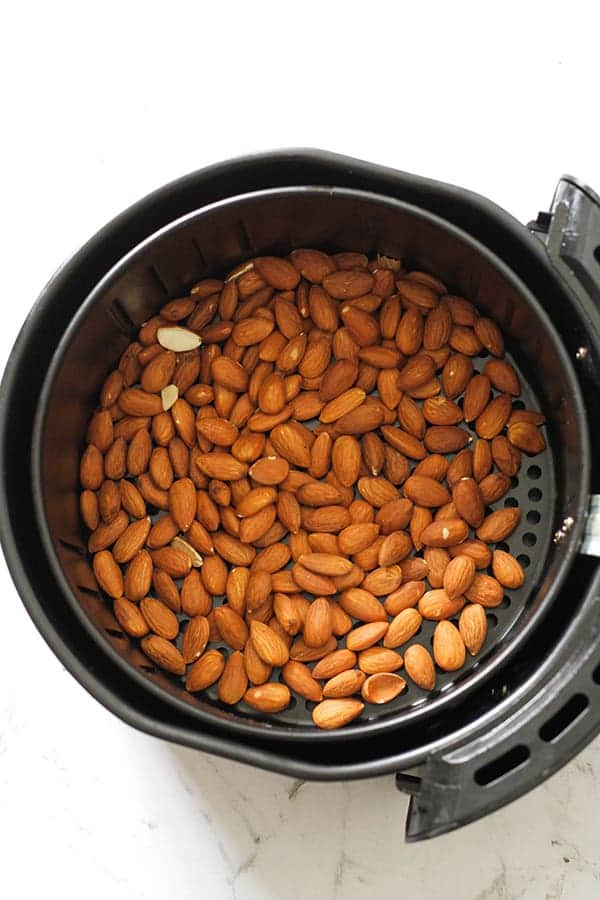 plain almonds in an air fryer basket.