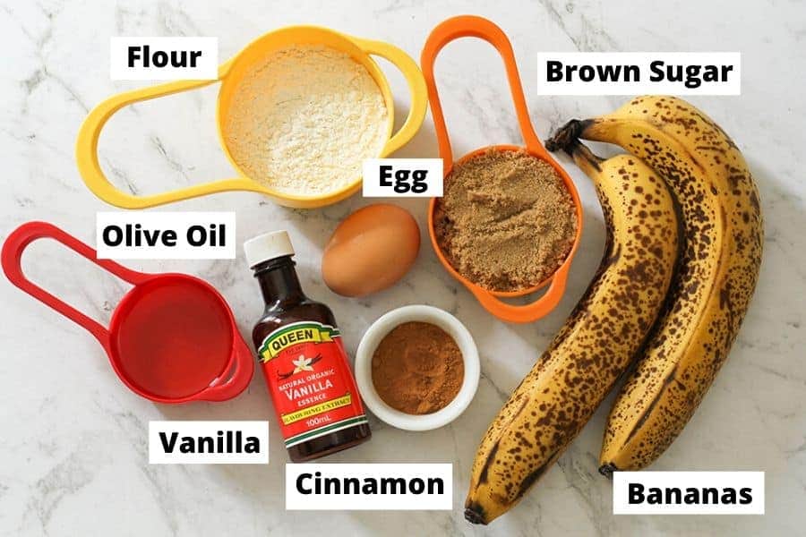 Air Fryer Banana Muffins Ingredients on a white marble background.