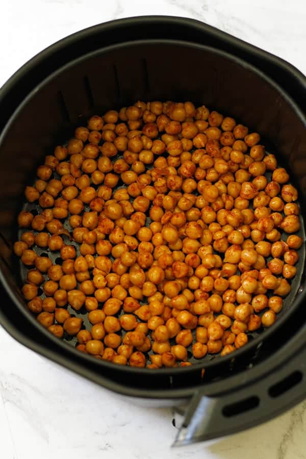 chickpeas in an air fryer basket.