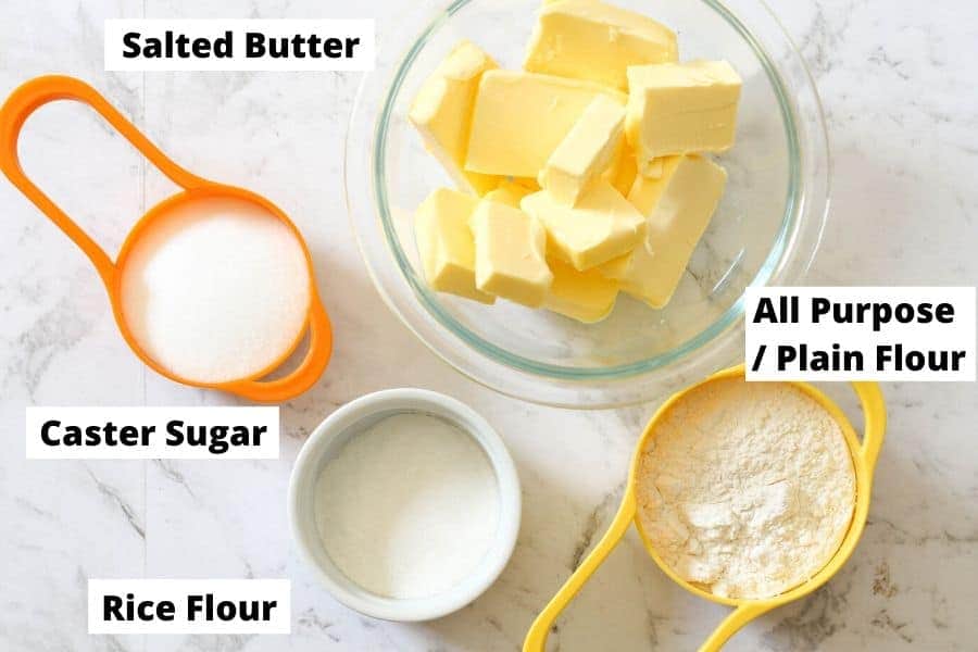 shortbread ingredients laid on a white marble background.