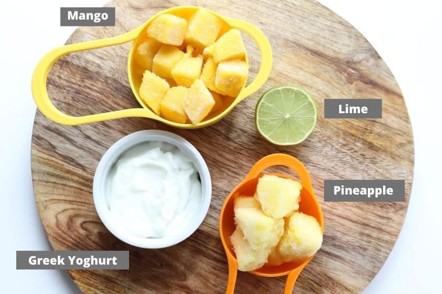 mango popsicles ingredients on a wooden board.