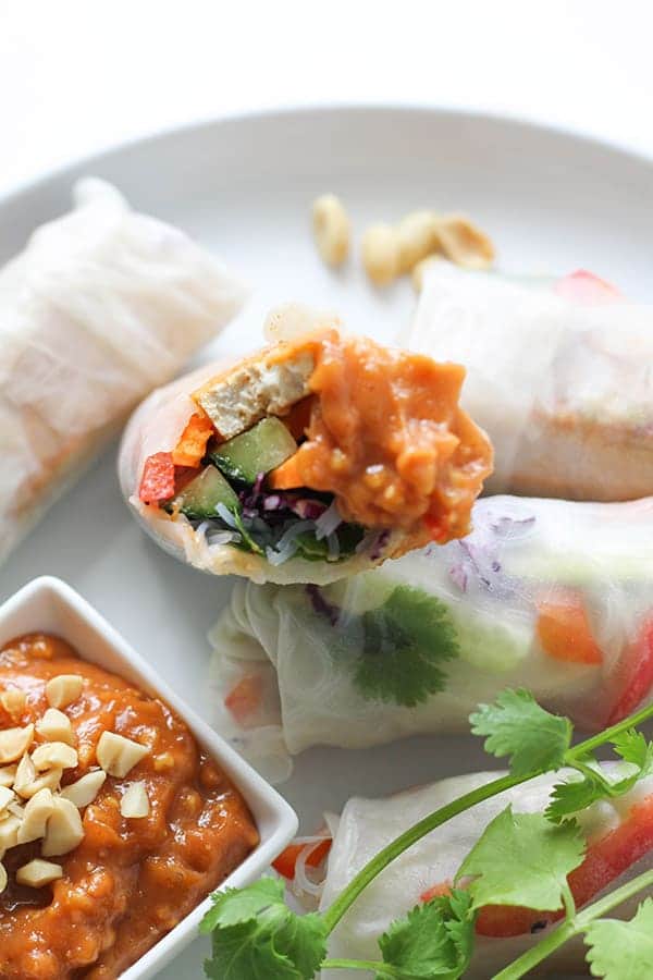 close up of a rice paper roll topped with peanut sauce.