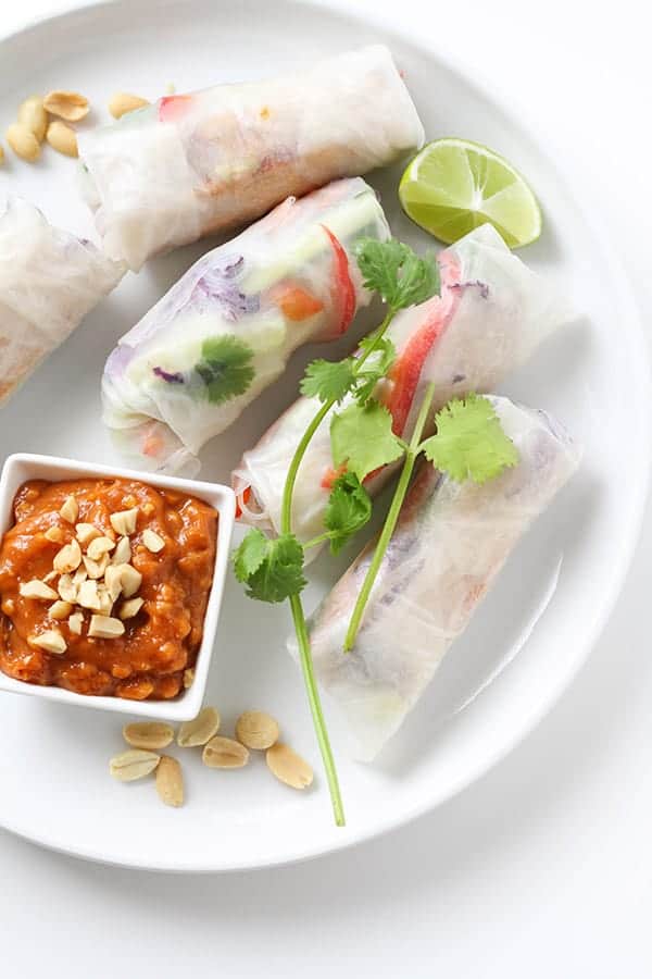 a white plate filled with rice paper rolls.