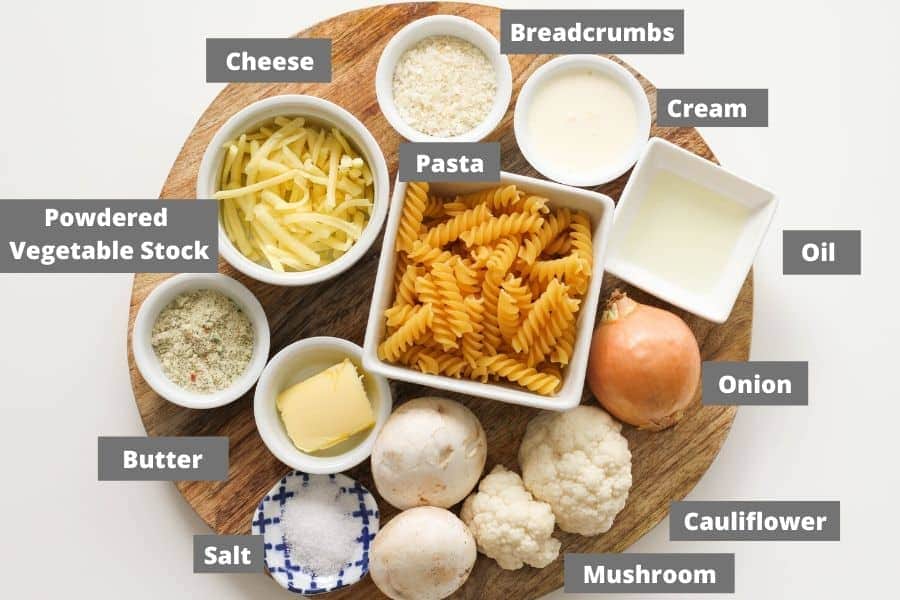 ingredients for creamy vegetable pasta on a wooden board.