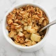 apple crisp in a white ramekin with a spoon.