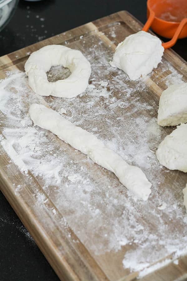dough rolled into a rope on a wooden board.