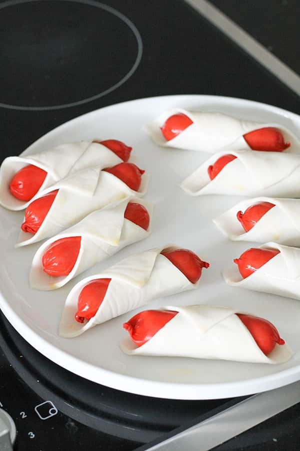 cocktail frankfurts wrapped in puff pastry on a plate.