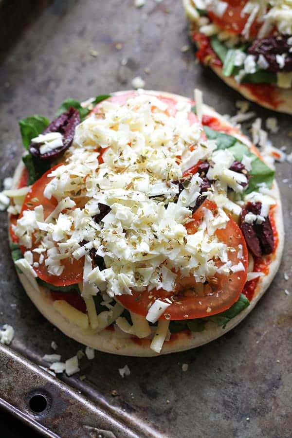 uncooked pizzas on a baking tray.