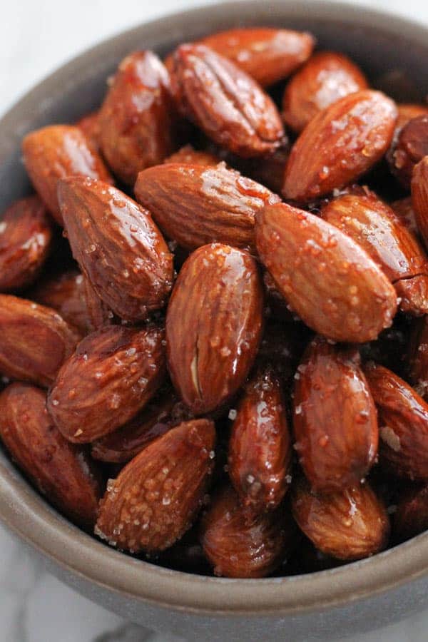 honey roasted almonds in a grey bowl.