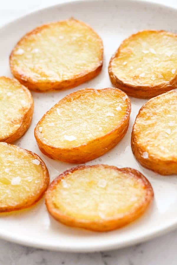 crispy salt and vinegar potatoes on a white plate.