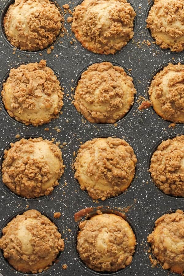 cooked cinnamon muffins in a muffin tray.
