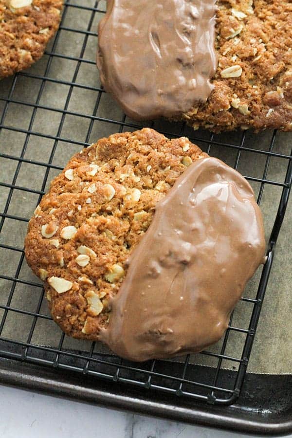 chocolate anzac biscuits on a wire rack.
