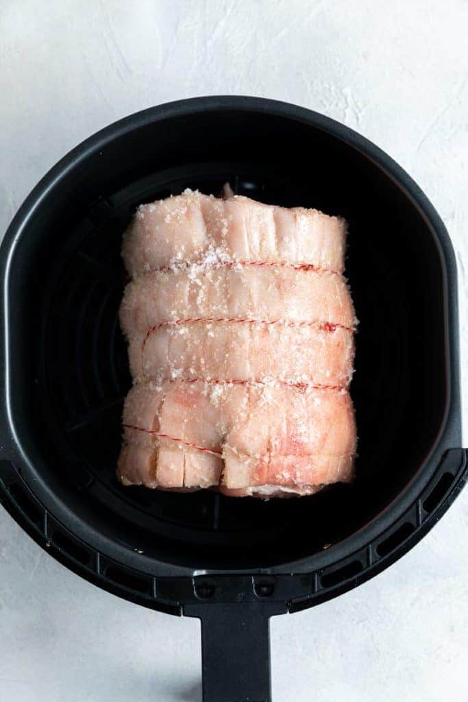 pork roast in an air fryer basket.