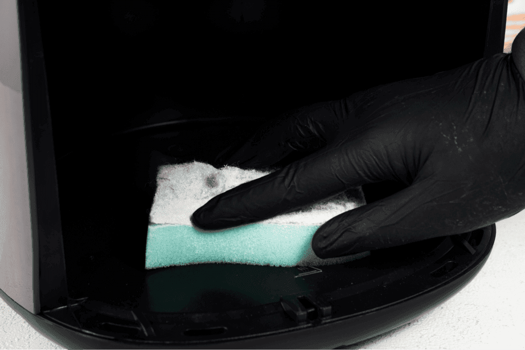 Cleaning air fryer interior with sponge